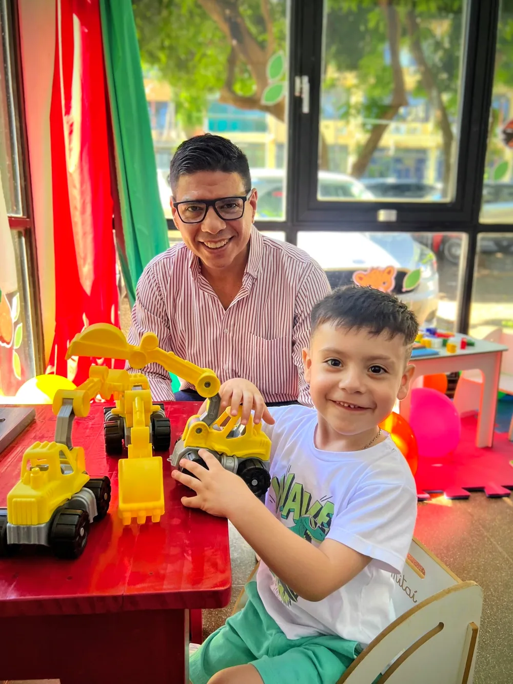 Fernando, de lentes, jugando con un nene en un Espacio de Primera Infancia